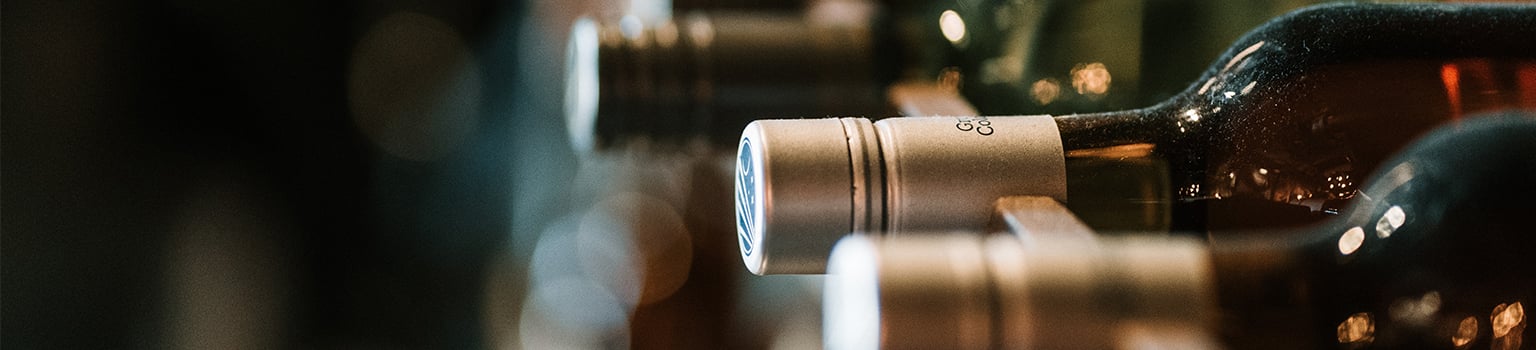 Bouteilles de vins alignées dans une cave.